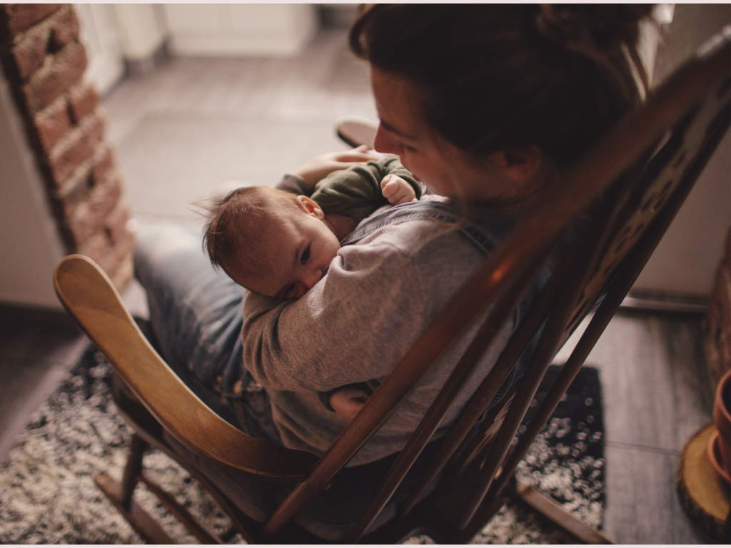 la mare, asseguda en un balancí, bressola i canta al seu nadó per fer-lo dormir. Cançons de bressol.